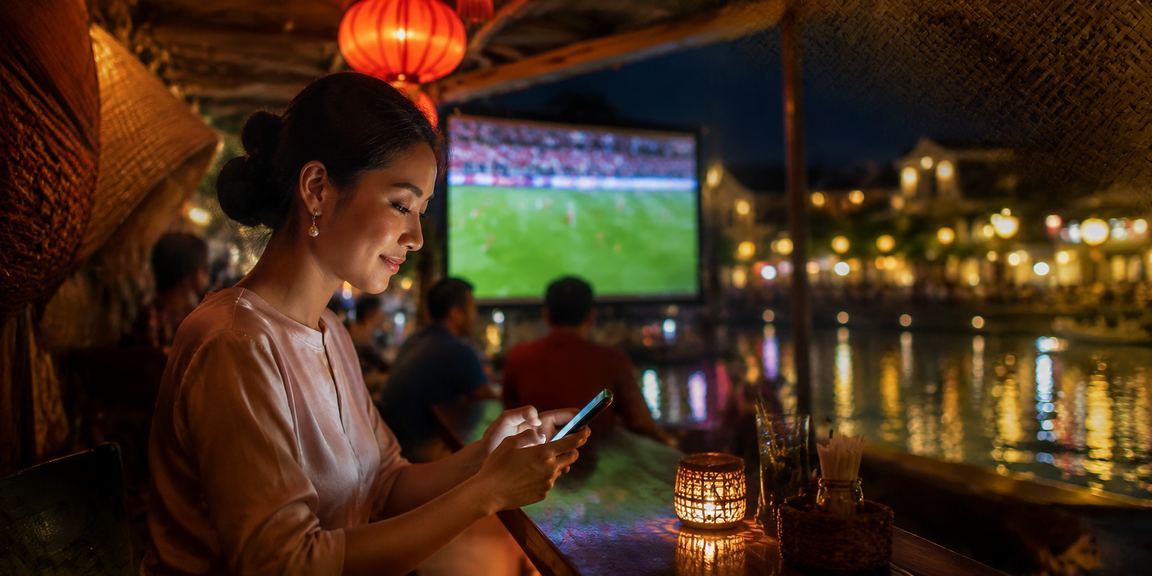 Người dùng theo dõi kèo bóng đá Việt Nam qua điện thoại tại Hội An